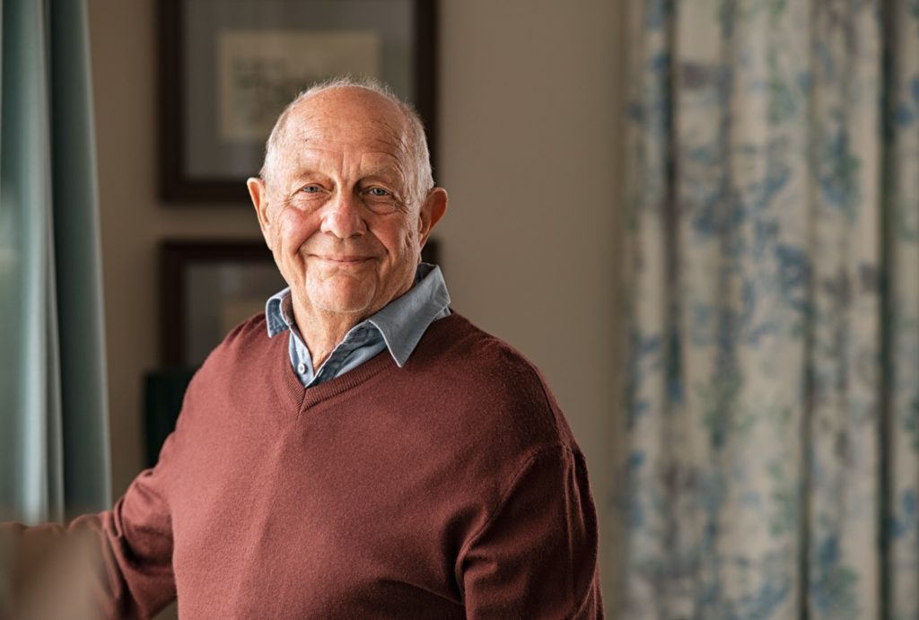 A portrait of a senior man enjoying his home in a memory care community.