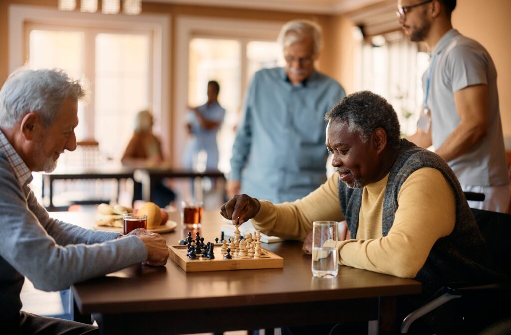 A group of seniors within a senior living community playing chess together.